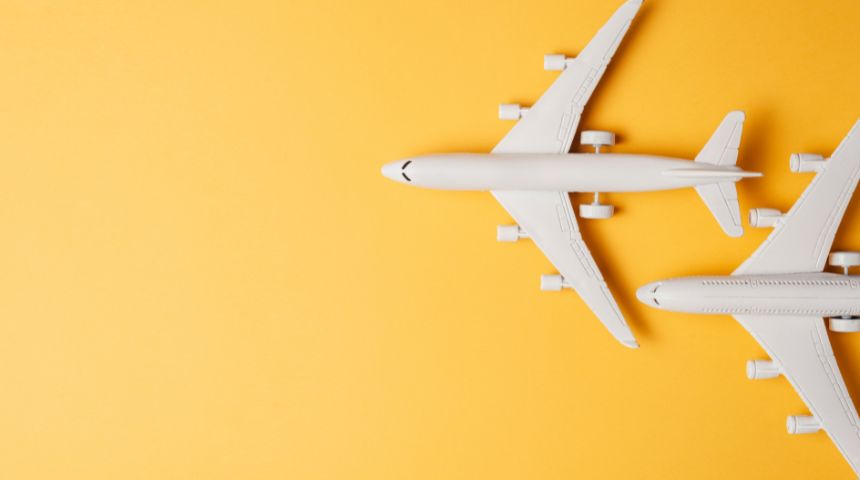 Two white airplanes against a bright yellow background.